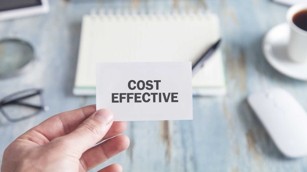 Hand holding a card reading “COST EFFECTIVE,” symbolizing the financial benefits of outpatient treatment for teens.