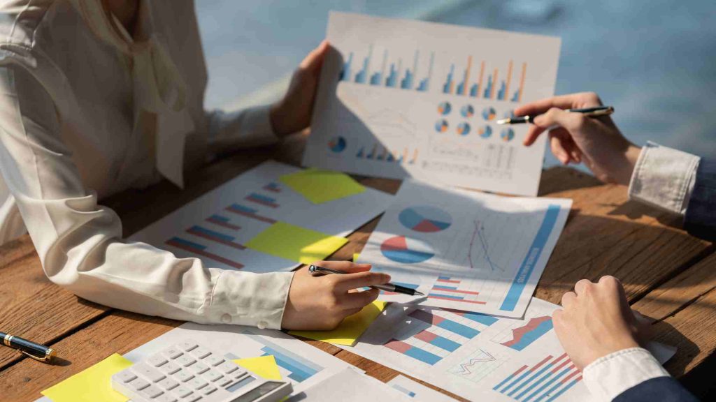 Close-up of people analyzing financial charts and reports, symbolizing factors that affect the cost of teen therapy in Arizona.