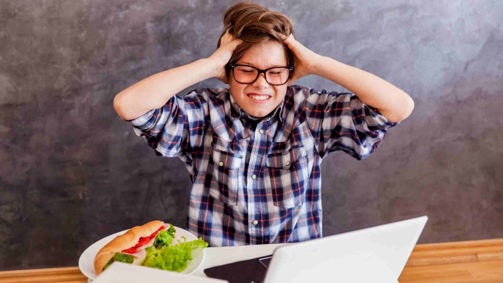 Frustrated teen pulling hair in anger, symbolizing conditions that may require teen PHP or IOP.