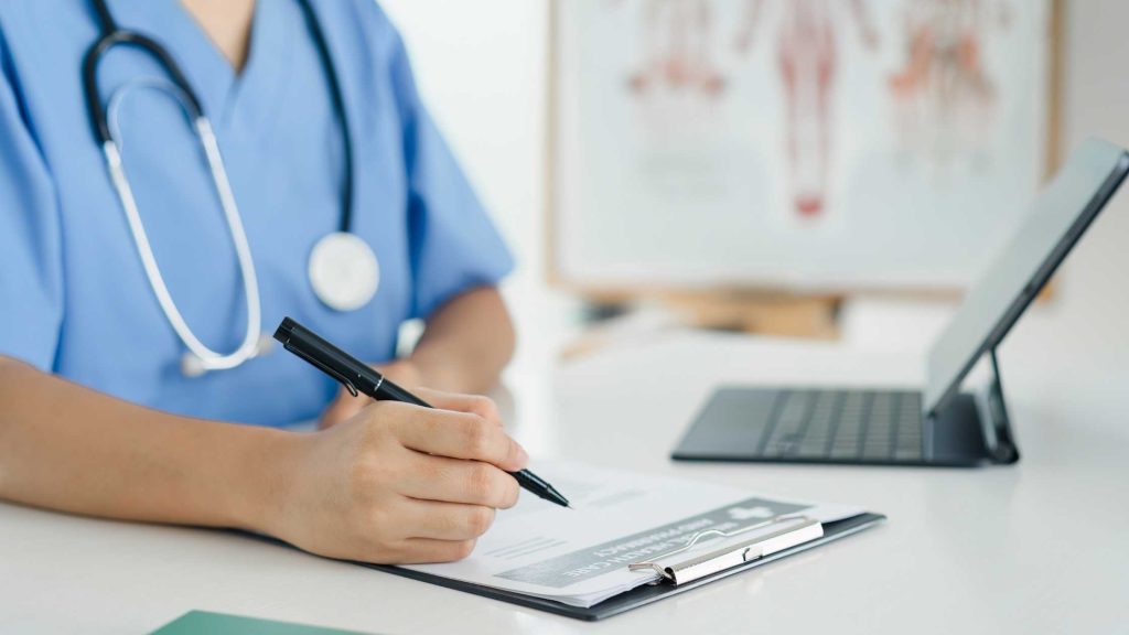 Doctor reviewing an initial assessment on a clipboard, representing the first step in structured teen outpatient treatment.
